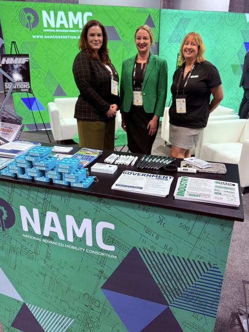 Veronica, Lia, and Deena standing behind the NAMC reception desk.
