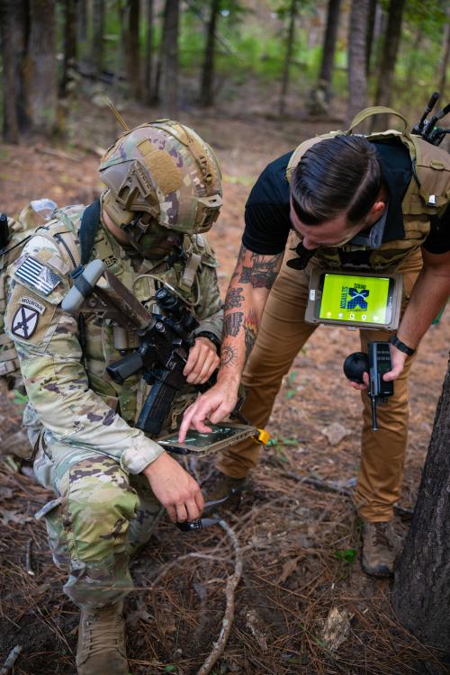 Dean Wurzell with Soldier looking at remote display in the forrest.